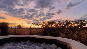 A hot tub with a view of a sunset and a power line tower in the background. - Villa Safari Golf & Spa - Toulouse - prox. Airbus (Plaisance-du-Touch)