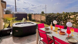 A patio with a hot tub, dining table, and chairs. - Villa Safari Golf & Spa - Toulouse - prox. Airbus (Plaisance-du-Touch)