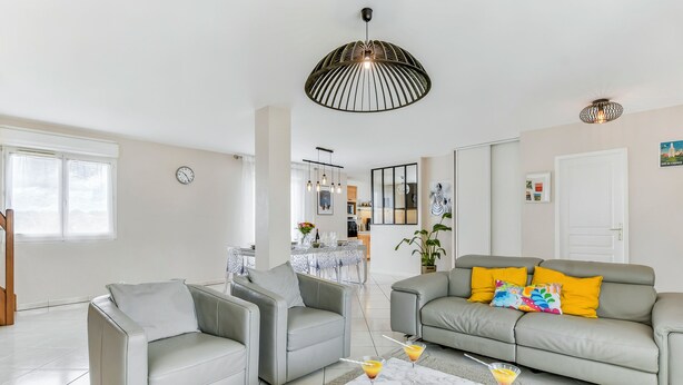 A modern living room with grey sofas, a coffee table with drinks, and a dining area in the background. - Villa Safari Golf & Spa - Toulouse - prox. Airbus (Plaisance-du-Touch)