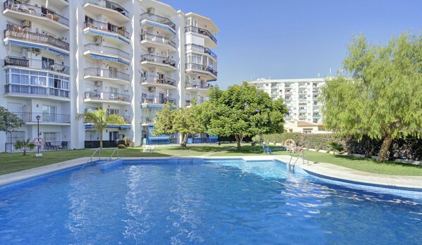 A swimming pool surrounded by a well-maintained lawn and trees. - Ref. 639037 (Nerja)