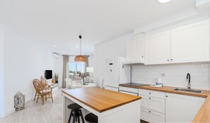 A modern kitchen with white cabinets, a wooden countertop, and a built-in oven. - Ref. 639037 (Nerja)