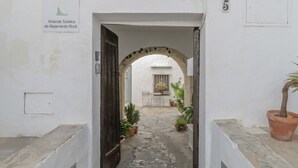 Un sendero estrecho que conduce a una edificación rústica con un letrero que indica que es un alojamiento rural.