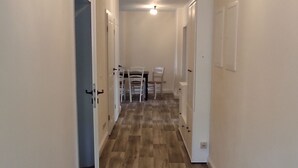 A hallway with wooden flooring, white walls, and a ceiling light fixture. - Apartment Wernerstr in the center - 3 bedrooms (Cottbus)