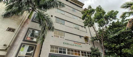 A multi-story building with a sign for 'Emerald Suites' and a 'By Classio' establishment.