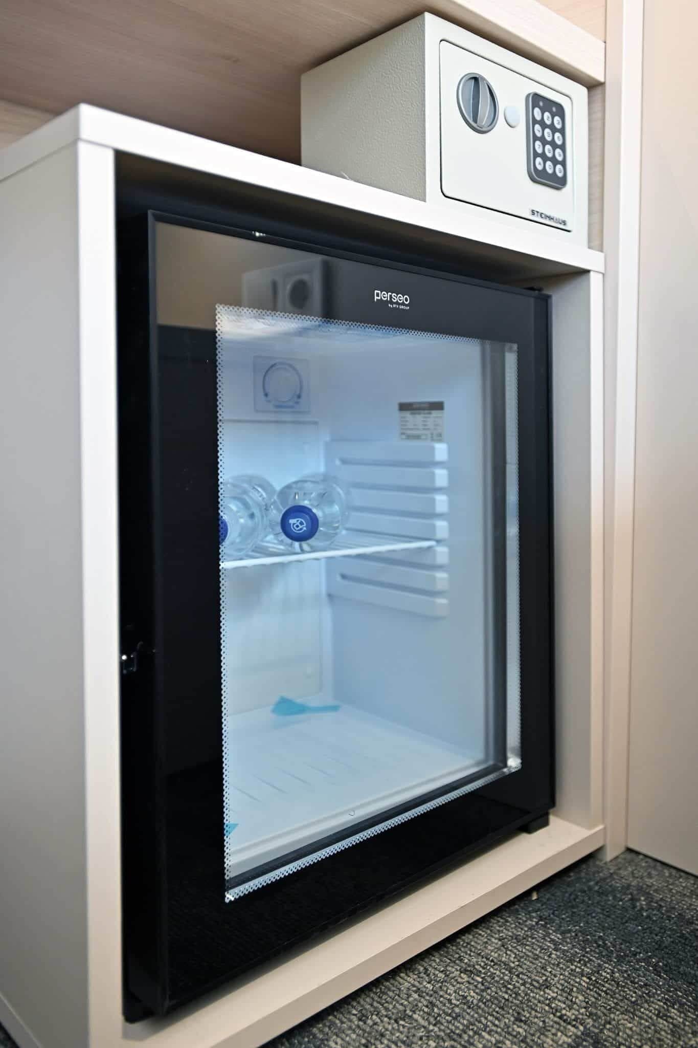 A compact refrigerator with a glass door, a control panel, and a water dispenser.