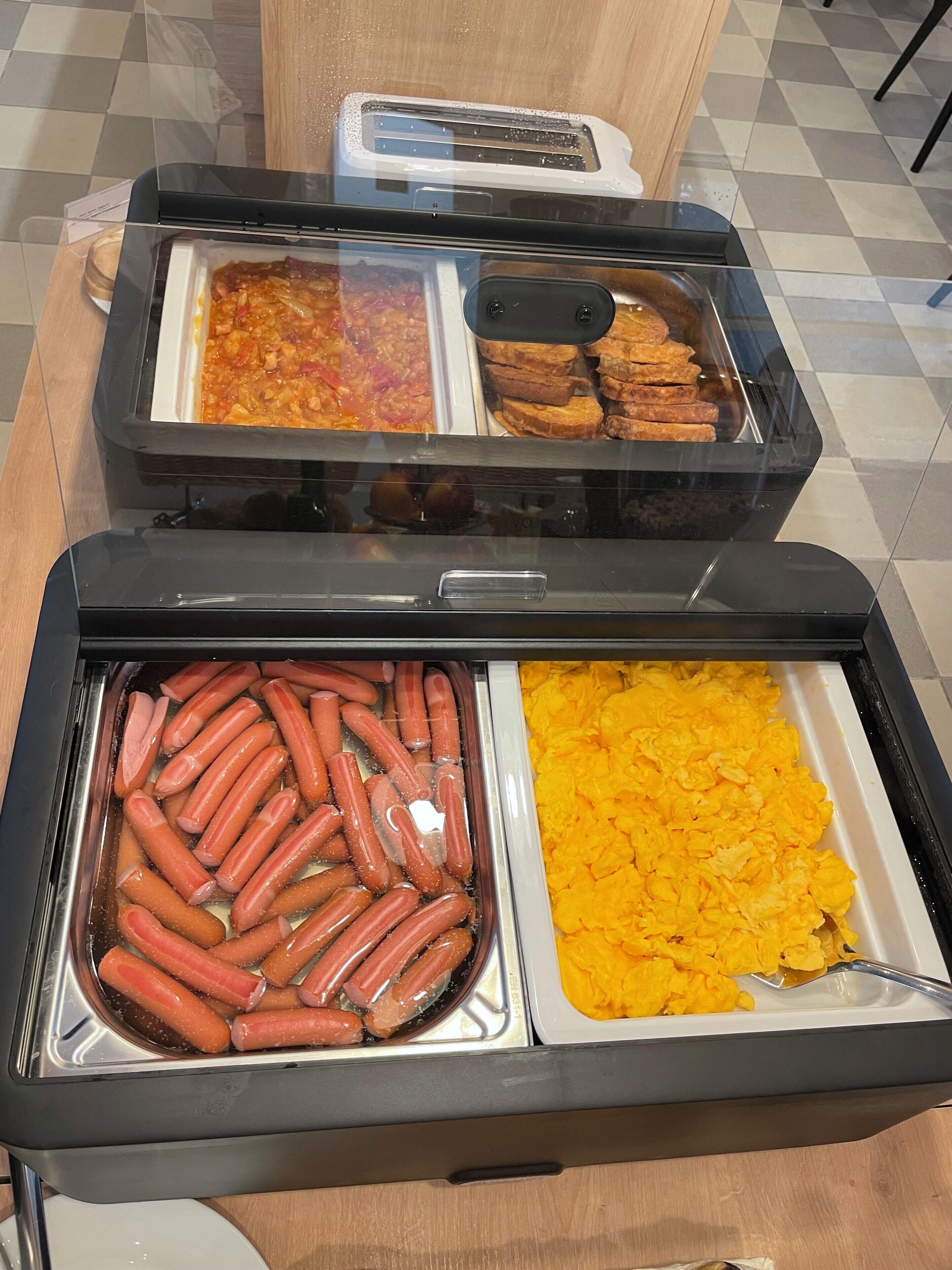 Ein Buffet mit Hotdogs, Rührei und Toast.