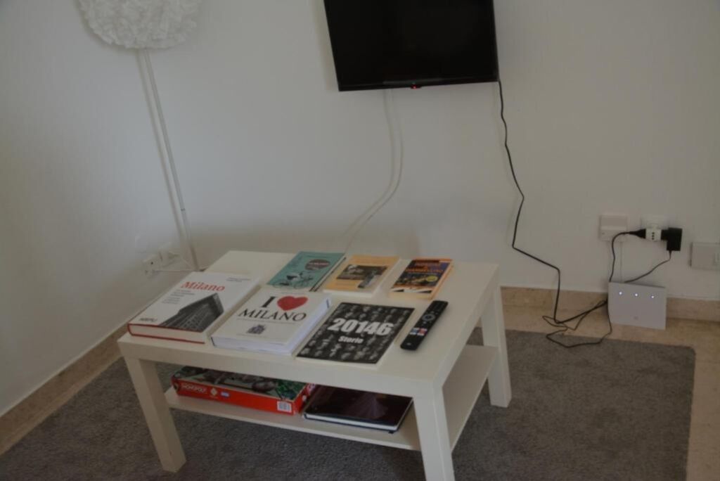A small white table with books and a remote control.