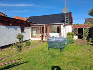 Ein Haus mit Satellitenschüssel, Garage und kleinem Garten.
