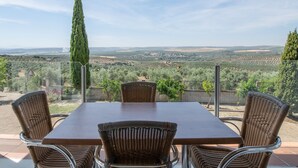 A patio with a table and chairs, overlooking a scenic landscape.