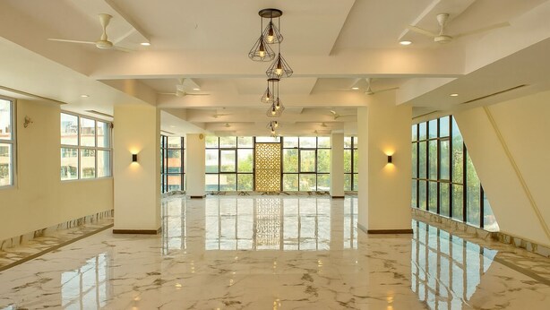 A spacious hotel lobby with marble flooring, large windows, and a decorative light fixture. - HOTEL KARDHAR INN (Ambaji)