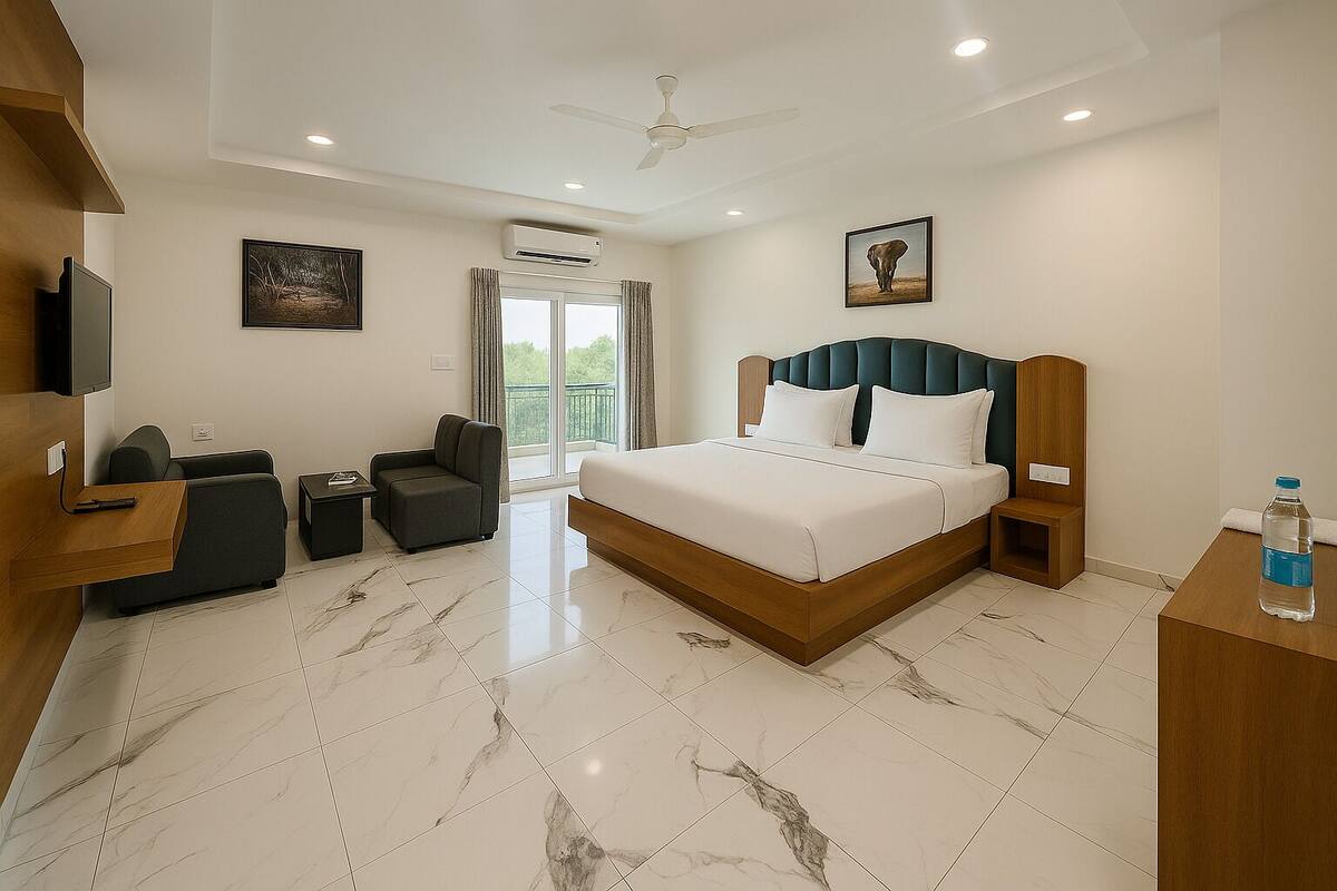 A modern hotel room with a large bed, a desk, a chair, and a TV.