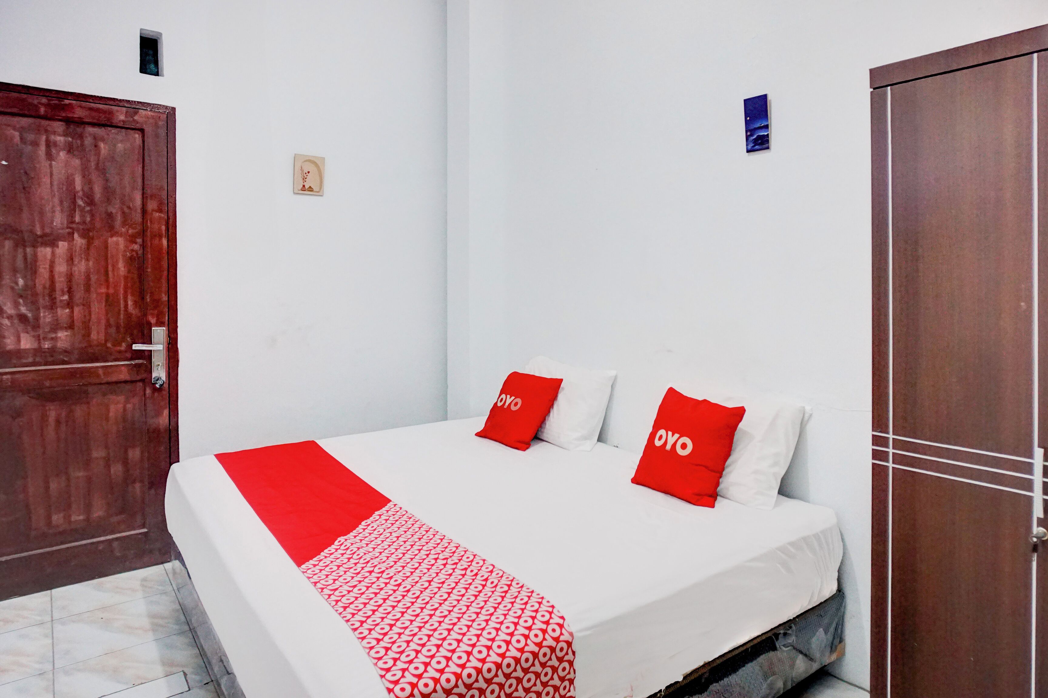 A room with a bed, a wooden door, and a wardrobe.