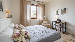 A bedroom with a bed, a desk, and a chair. - Scena Illustrata-Redi 51-un to 10 people (Florence)