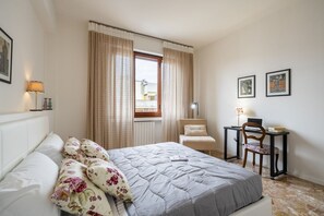 Een slaapkamer met een bed, een bureau en een stoel.