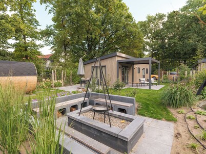 Genießen Sie ein luxuriöses Ferienhaus für vier Personen inmitten der waldreichen Natur der Veluwe. Es bietet moderne Annehmlichkeiten, Klimaanlage und eine stilvolle Pergola für höchsten Komfort. Entspannen Sie sich nach einem Tag in der Natur im he