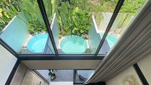 Ein modernes Interieur mit Glasdecke, Schwimmbad und einer Treppe.