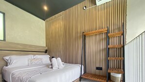 Ein modernes Schlafzimmer mit einem Bett, einer Wand aus Holzlatten, einer Holzleiter und einem kleinen Regal.