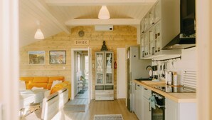 Um interior acolhedor com sala de estar, cozinha e corredor que leva a uma porta com a inscrição 'HOME'.