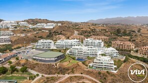 A residential area with modern apartment buildings, a parking lot, and a green sports field. - Hermanos | Sea views - pool - terrace (La Cala de Mijas)