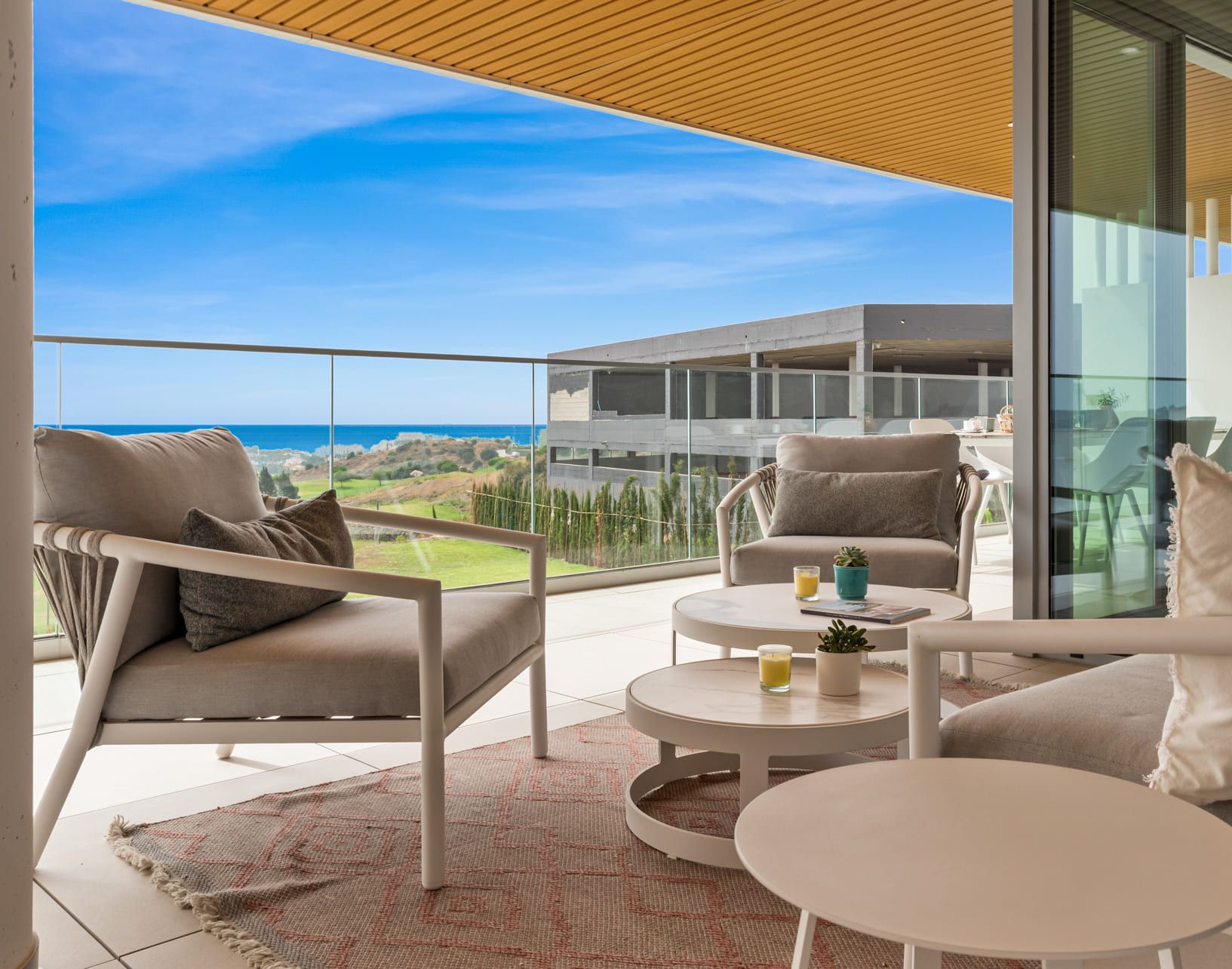 Ein Balkon mit Meerblick, ausgestattet mit zwei Sofas und einem kleinen Tisch.