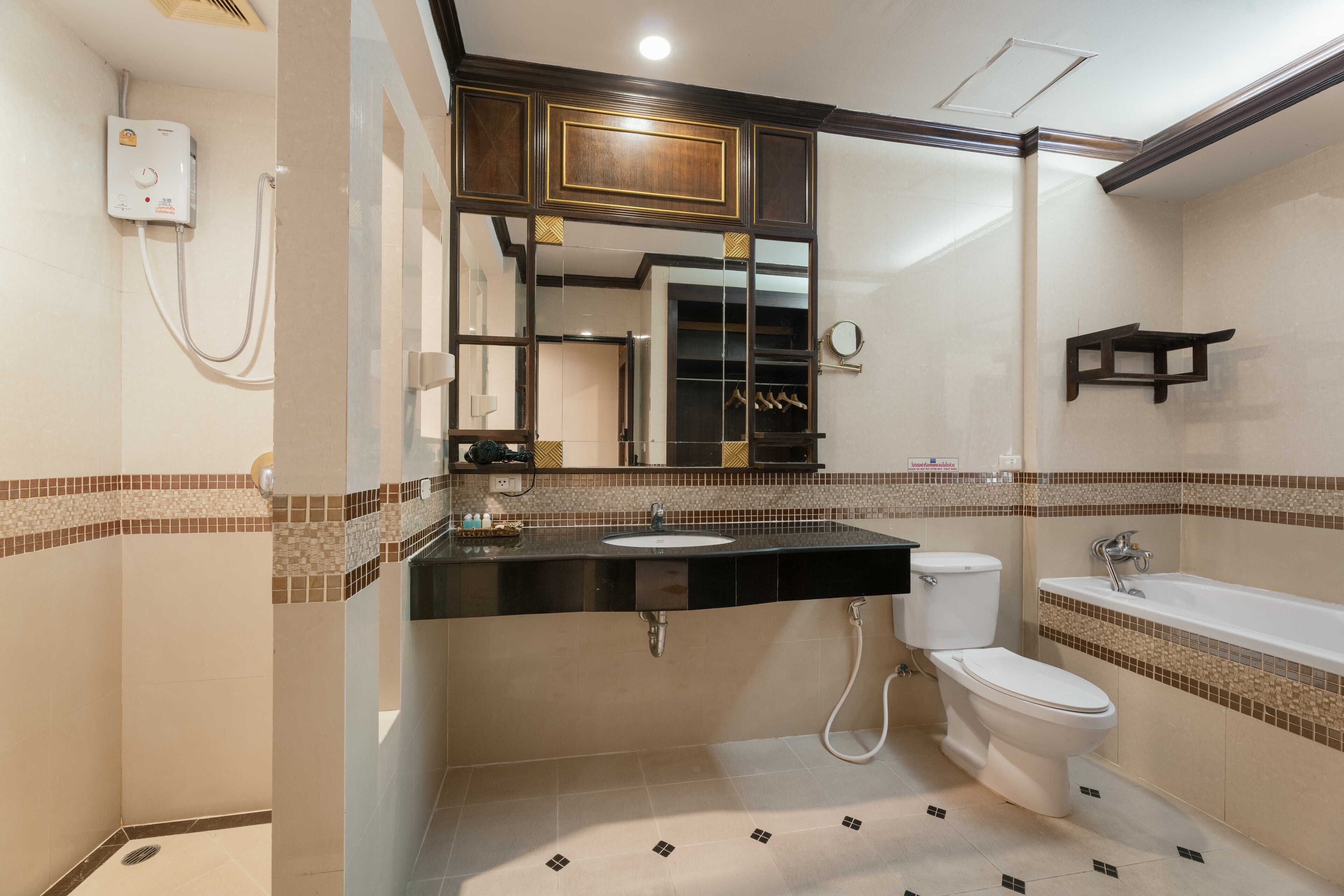 Une salle de bain avec douche, toilettes et baignoire.