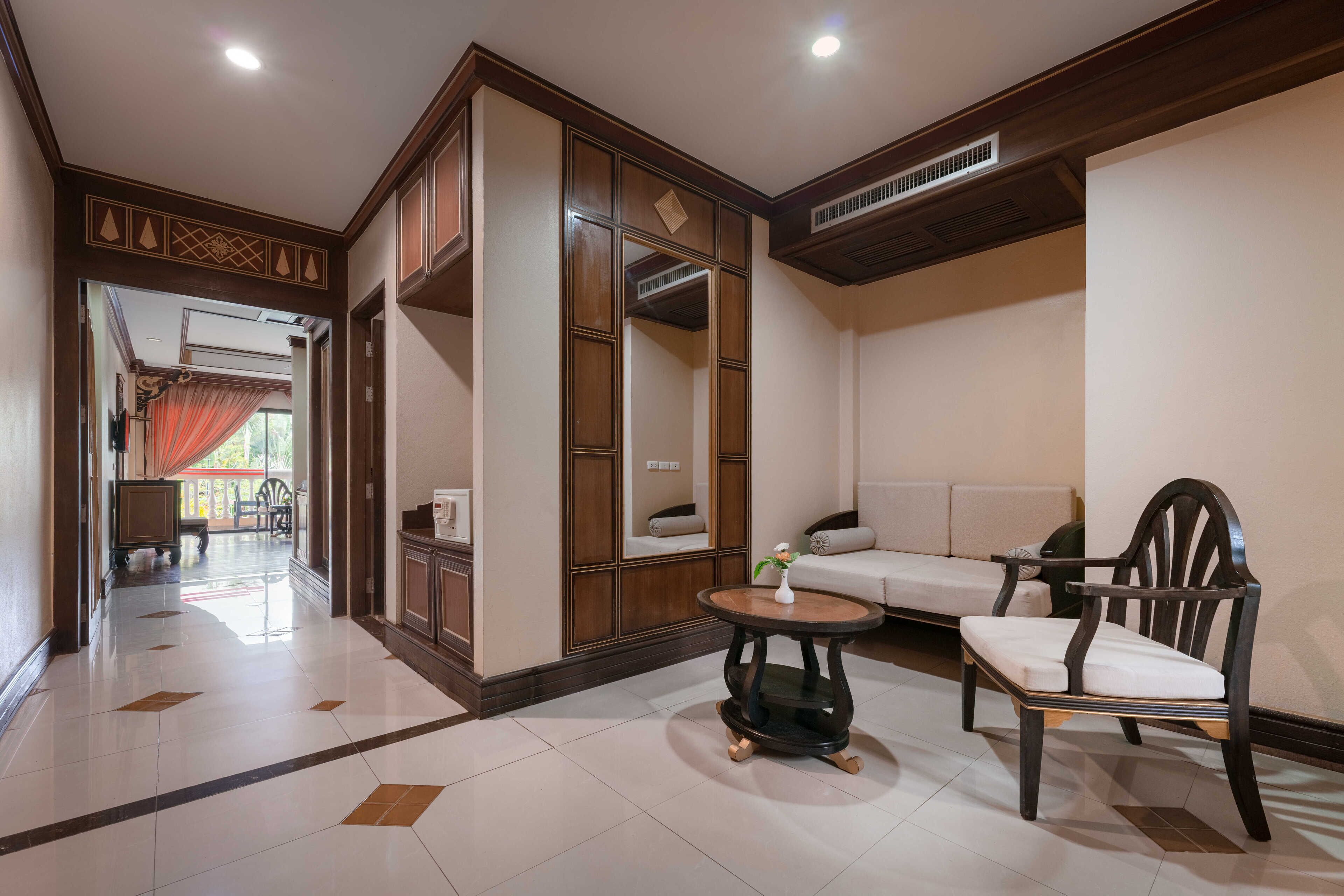 A spacious living area with a sofa, a wooden chair, and a small round table.