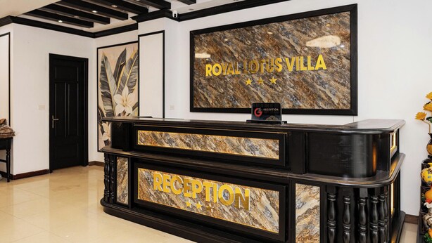 A reception desk with a marble top and a sign that reads "RECEPTION" and "ROYAL LOTUS VILLA". - Royal Lotus Villa (Hanoi)