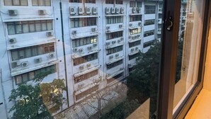 A view from a window of a multi-story building with air conditioning units, a door, and a view of other buildings. - Royal Lotus Villa (Hanoi)