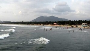 A beach with waves, people, and a mountain in the background. - Ocean View Residency (Bhatkal)
