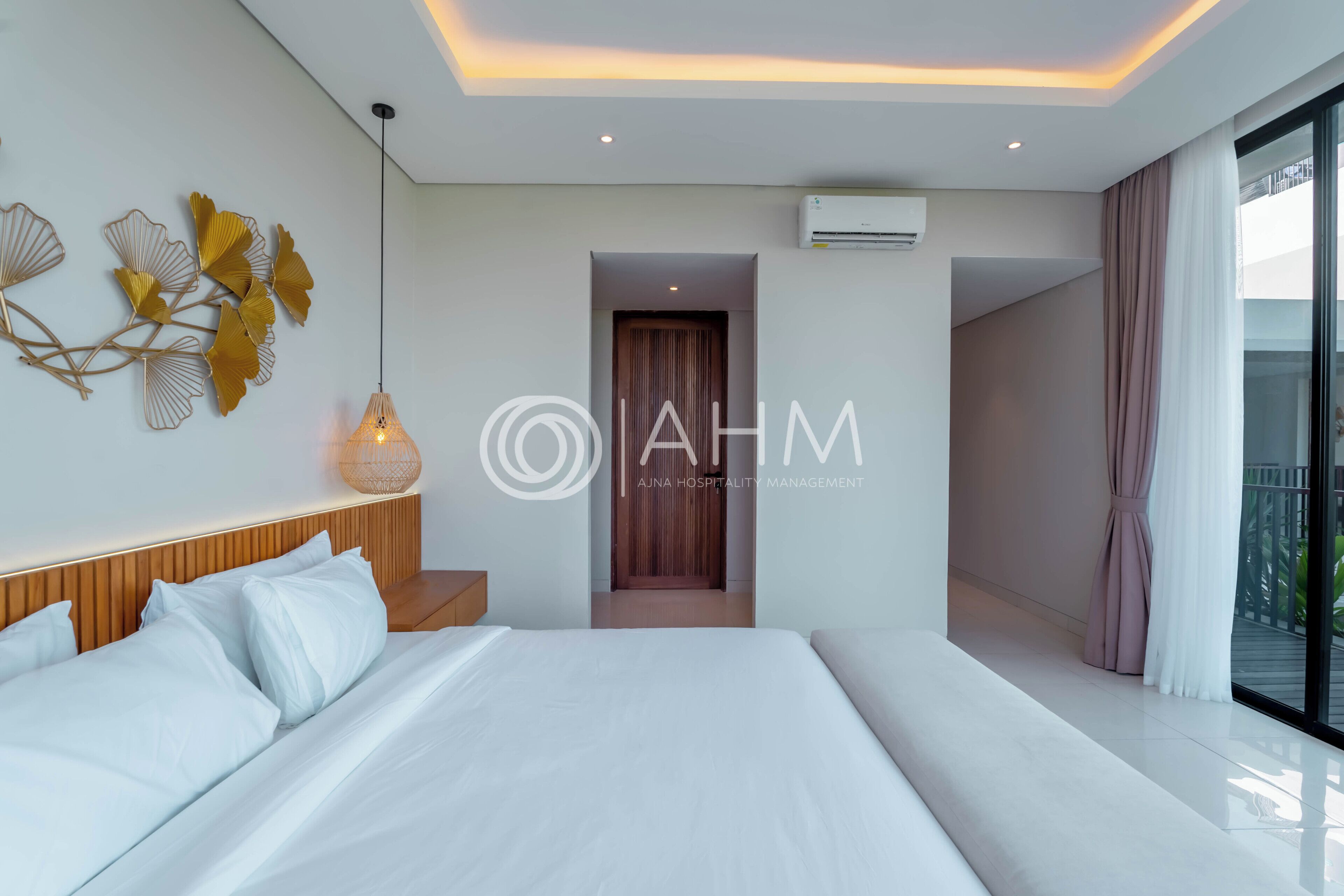 Una habitación de hotel moderna con una cama grande, una mesita de noche, un adorno en la pared y vistas al exterior.