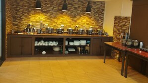 A kitchen with a stone backsplash, multiple cooking stations, and a variety of utensils and cookware. - Blue Poppy by Orangepetal (Gangtok)