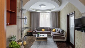 A modern living room with a sectional sofa, a coffee table, and a TV. - Spacious apartment near railway station (Minsk)