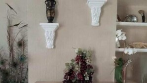A living room with a fireplace, a mantel decorated with a vase and a small sculpture, and a potted plant to the left. - Semi-detached house - Los Boliches - Fuengirola (FUENGIROLA)
