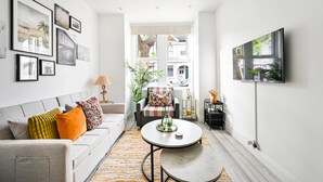 A modern living room with a sofa, coffee table, and artwork on the walls.