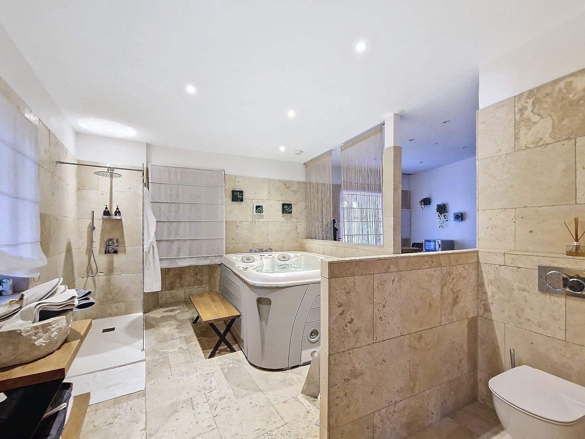 Un baño moderno con bañera, ducha, inodoro y tocador con espejo.