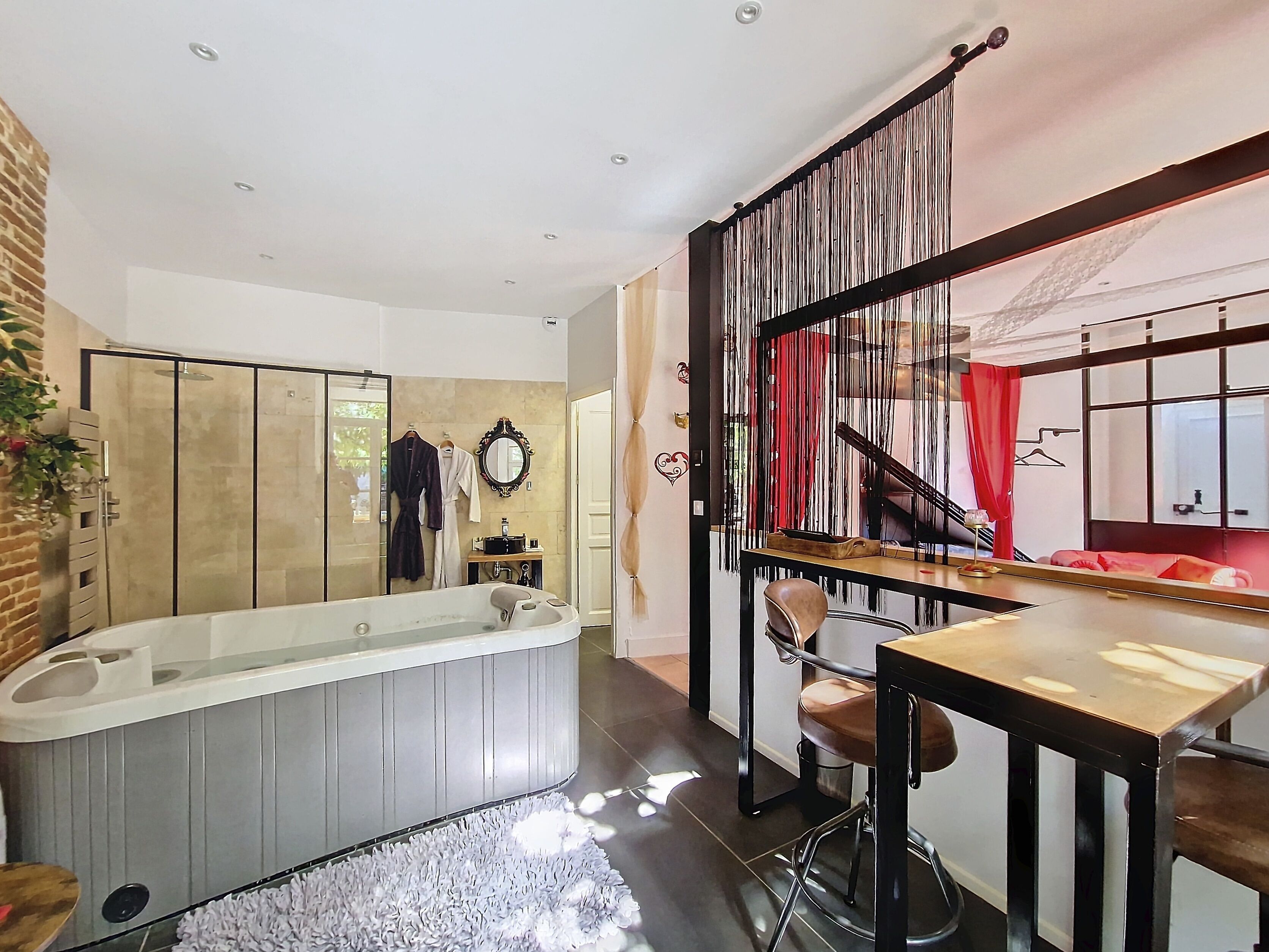 A modern bathroom with a bathtub, a vanity, and a mirror.