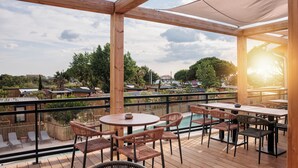 A wooden deck with outdoor seating, a pool, and a view of the surrounding area. - Blendin Agde  (Agde)