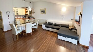 Un salon moderne avec un coin repas, un canapé et une cuisine en arrière-plan.