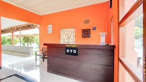 Un comptoir d’accueil avec une pancarte indiquant « Réception OYO » et un comptoir pour l’enregistrement du départ avec une pancarte indiquant « Départ le 13 janvier, hôtel Tlalnepantla ».