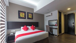 Une chambre d’hôtel avec un grand lit, un bureau et une télévision.