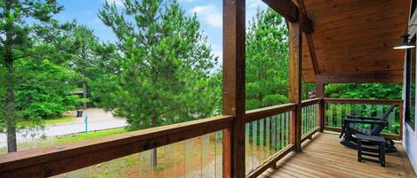 Una terraza de madera con vistas a un bosque.