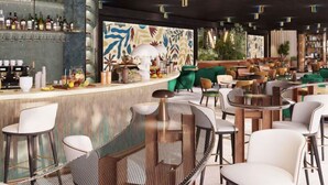 Un espace bar moderne offrant différents types de sièges, notamment des tables et des chaises rondes, ainsi qu’un comptoir avec un assortiment de bouteilles et de verres.