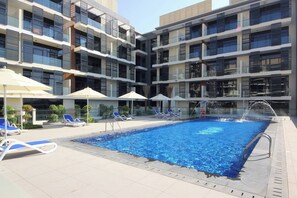 Outdoor pool - Manzil-Stylish 1BR with Maid room in JVC (Dubai)