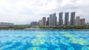 Una piscina con un paisaje urbano al fondo.