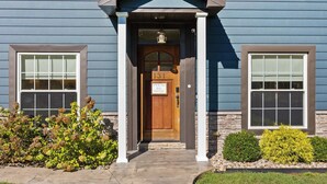 A two-story building with a wooden front door, a number plaque, and a small porch with a lantern. - Call Me Old Fashioned! *Heart of Bardstown Square* (Bardstown)
