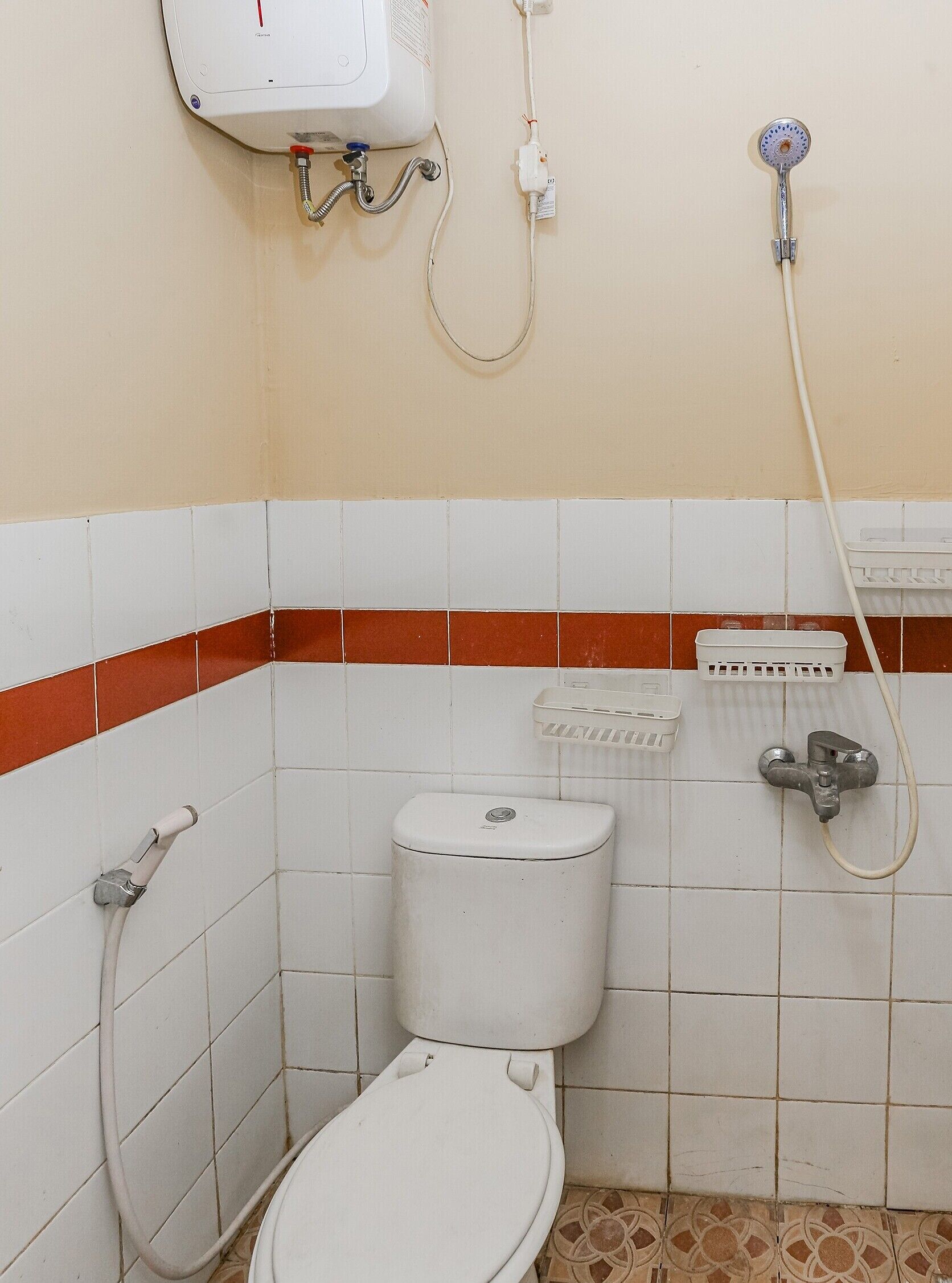 A small bathroom with a toilet, a shower, and a hand dryer.