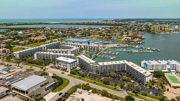 A coastal hotel with multiple buildings, a marina, and a view of the ocean.