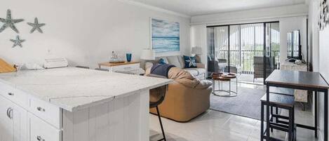 A modern living room with a large island, a sofa, and a dining area.