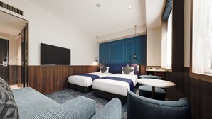 Una habitación de hotel moderna con una cama grande, dos mesitas de noche, un escritorio pequeño, un sofá y un televisor.