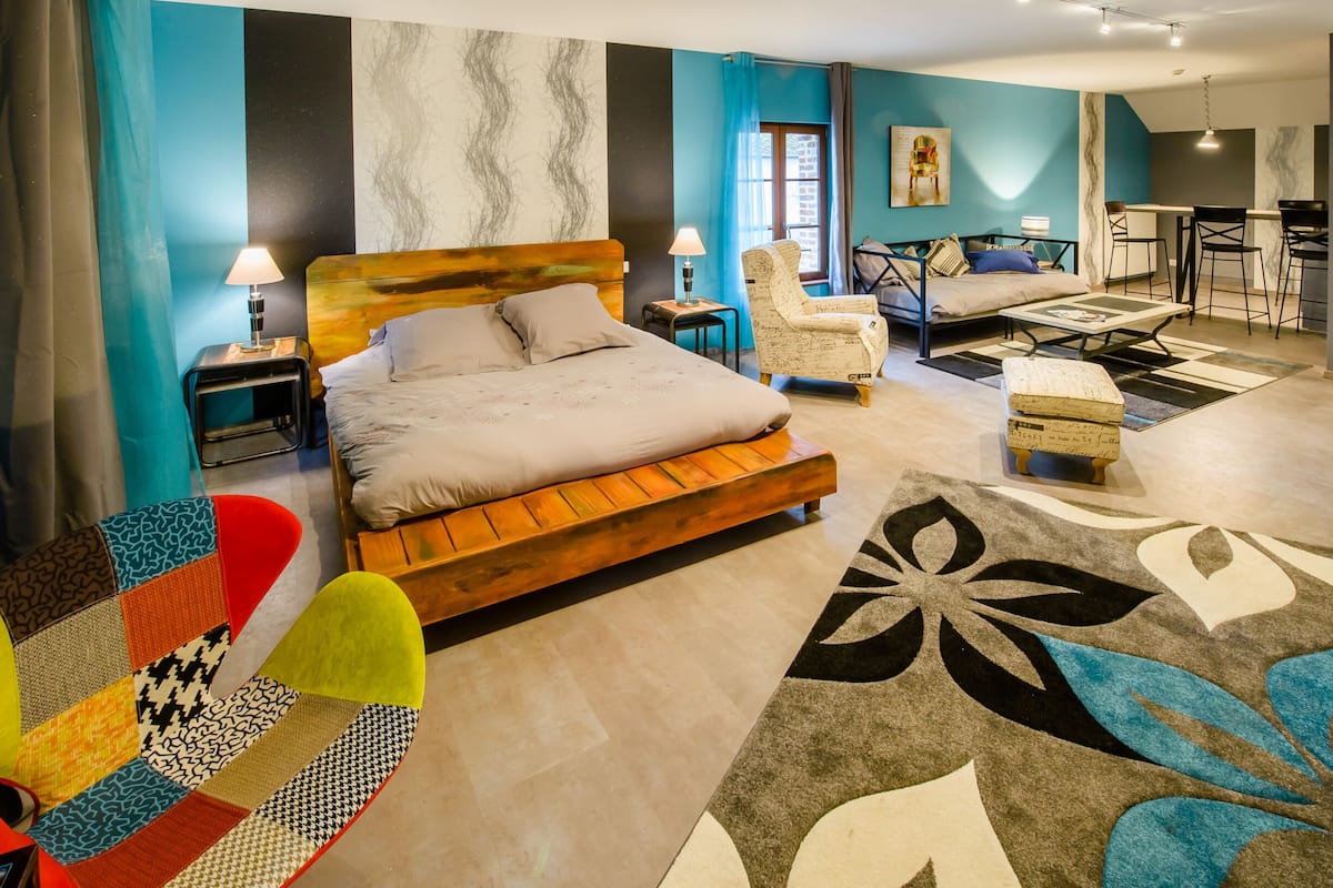 Une chambre d’hôtel moderne, dotée d’un grand lit, d’un bureau et d’un coin repas.